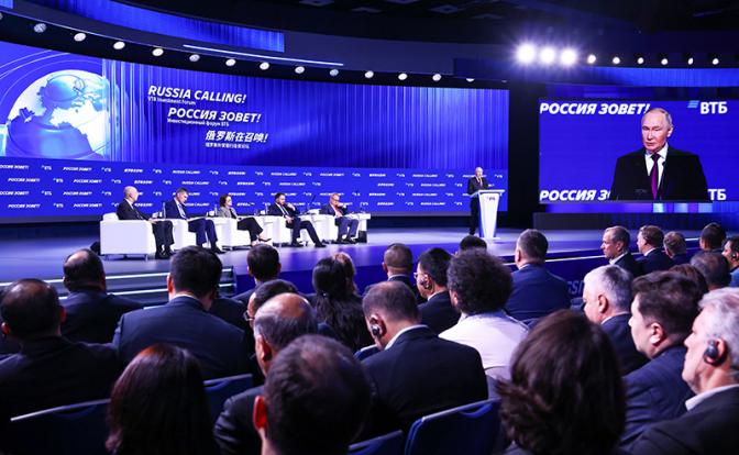 На фото: президент РФ Владимир Путин (на дальнем плане) на пленарном заседании инвестиционного форума ВТБ "Россия зовет!".