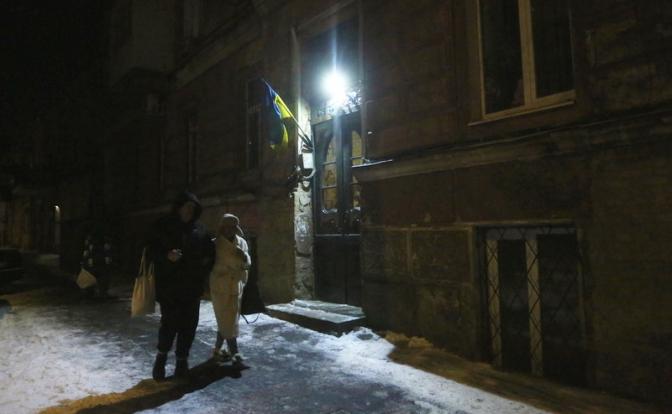 На фото: люди идут по темной, заснеженной улице Маркевича в Одессе.