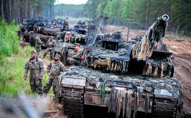 На фото: экипаж основного боевого танка NATO Leopard 2, оснащенного сетью защиты от дронов, ожидает продолжения своего пути.