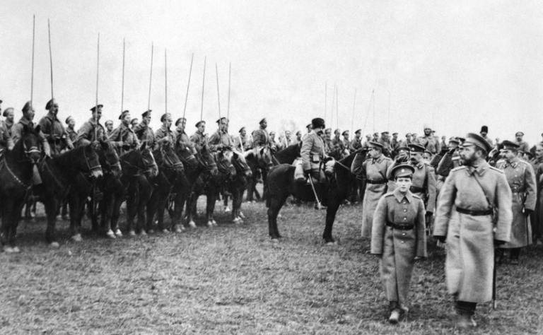На фото: император Николай II с сыном Алексеем проходит мимо казачьих войск, 1916 год.